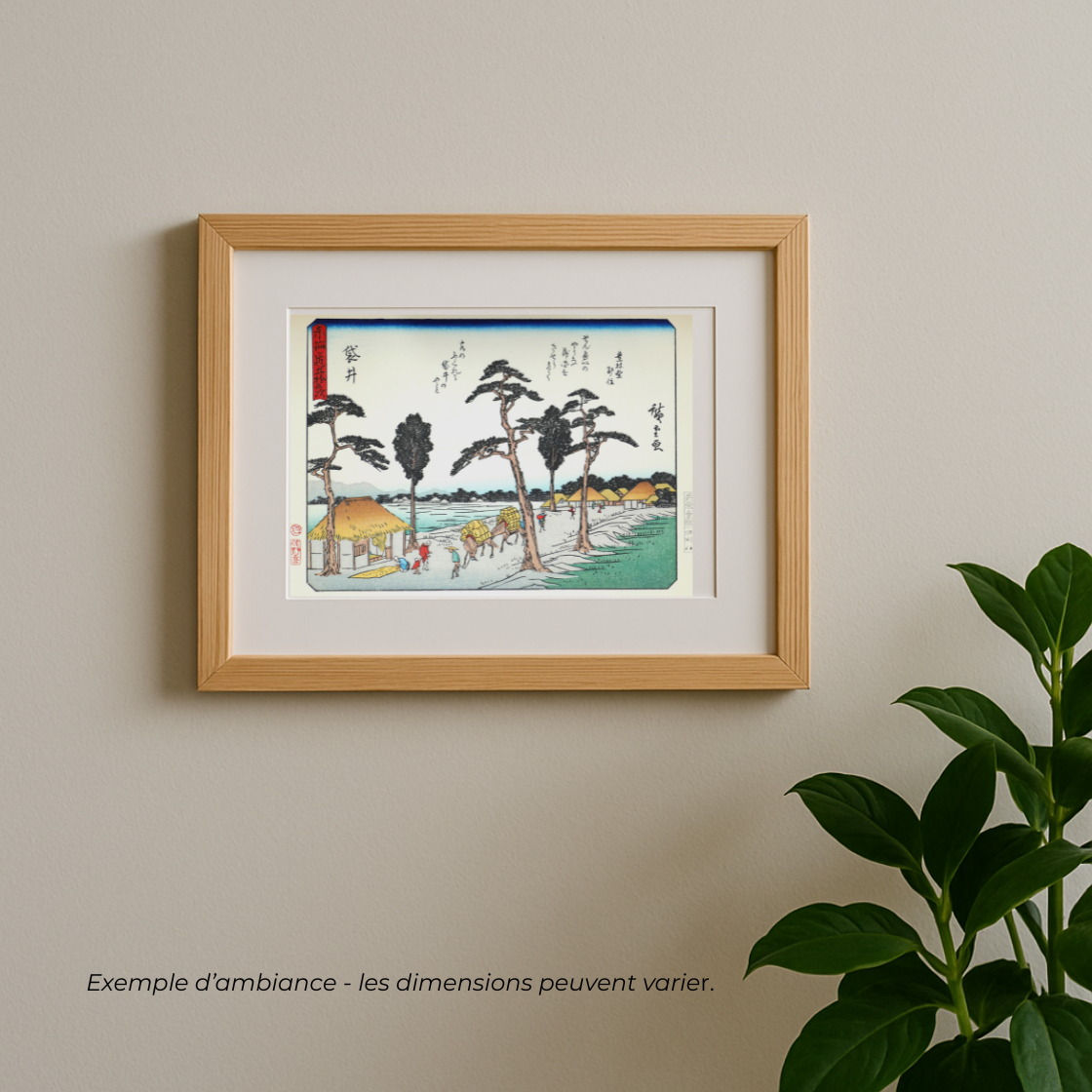 mise en scene d'une estampe de hiroshide du tokaido version kyoka station 28 dans un cadre en bois affiché au mur avec une plante à coté
