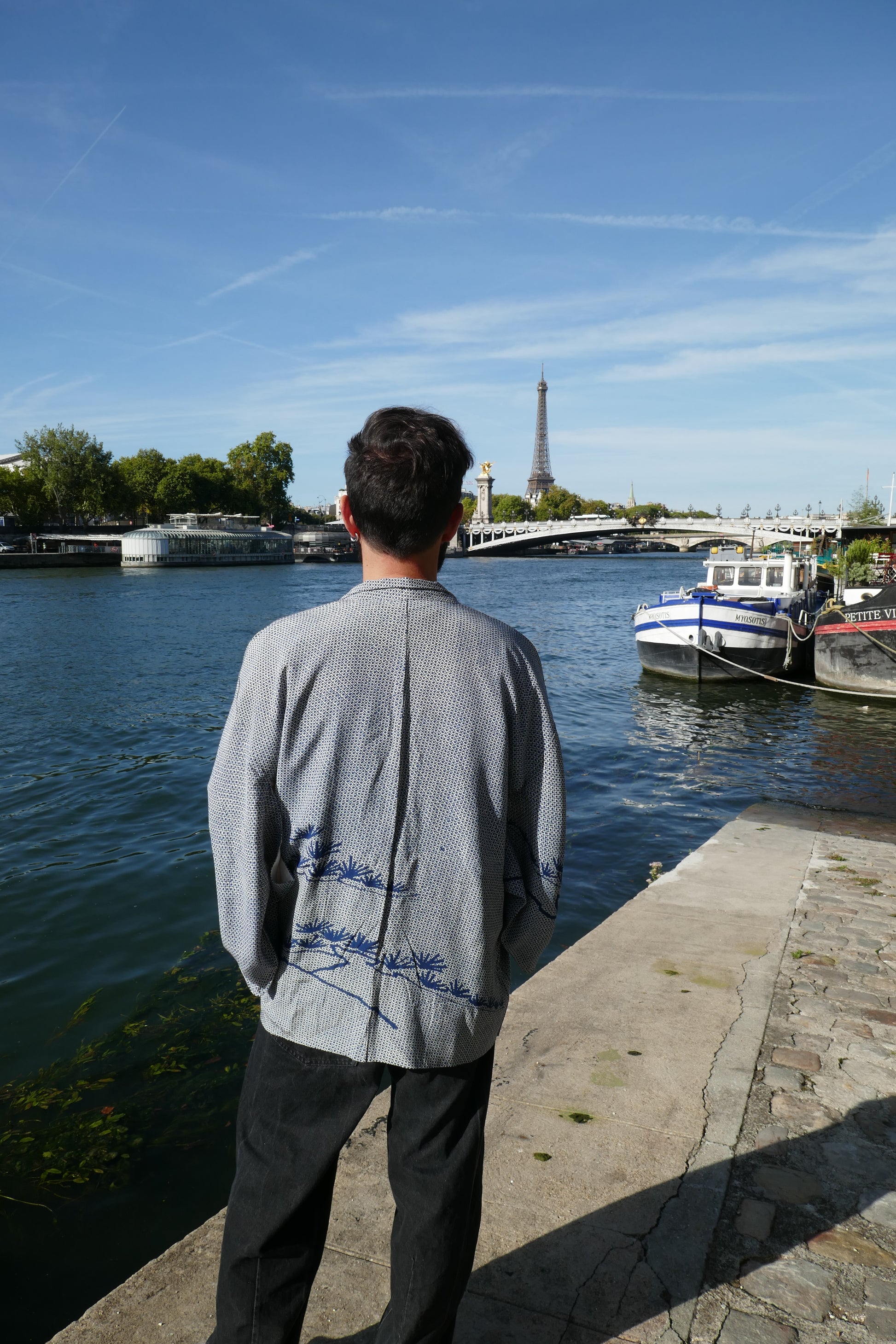 Veste kimono traditionnelle japonaise, haori vintage shibori bleu avec pin 松 dans le dos, portée par un homme à Paris près de la Seine.