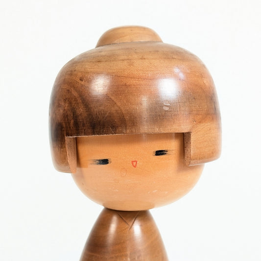 Gros plan du visage peint d’une sōsaku kokeshi de Fujikawa Masae Shōei, créateur japonais de Gunma