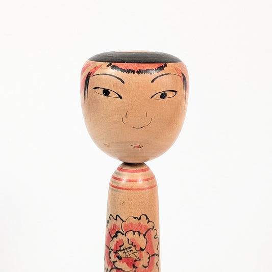 Détail du visage d’une poupée kokeshi Nakanosawa par Arakawa Yōichi, regard doux et expressif.