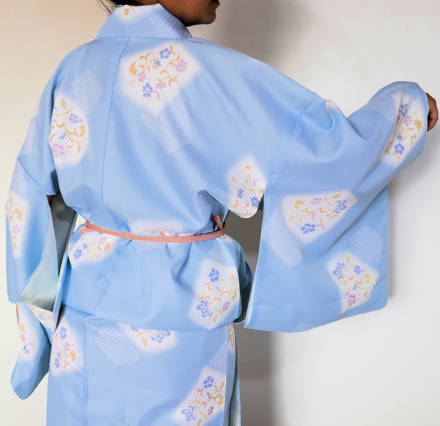 vue de dos du yukata bleu ciel fleuri attaché avec une obijime