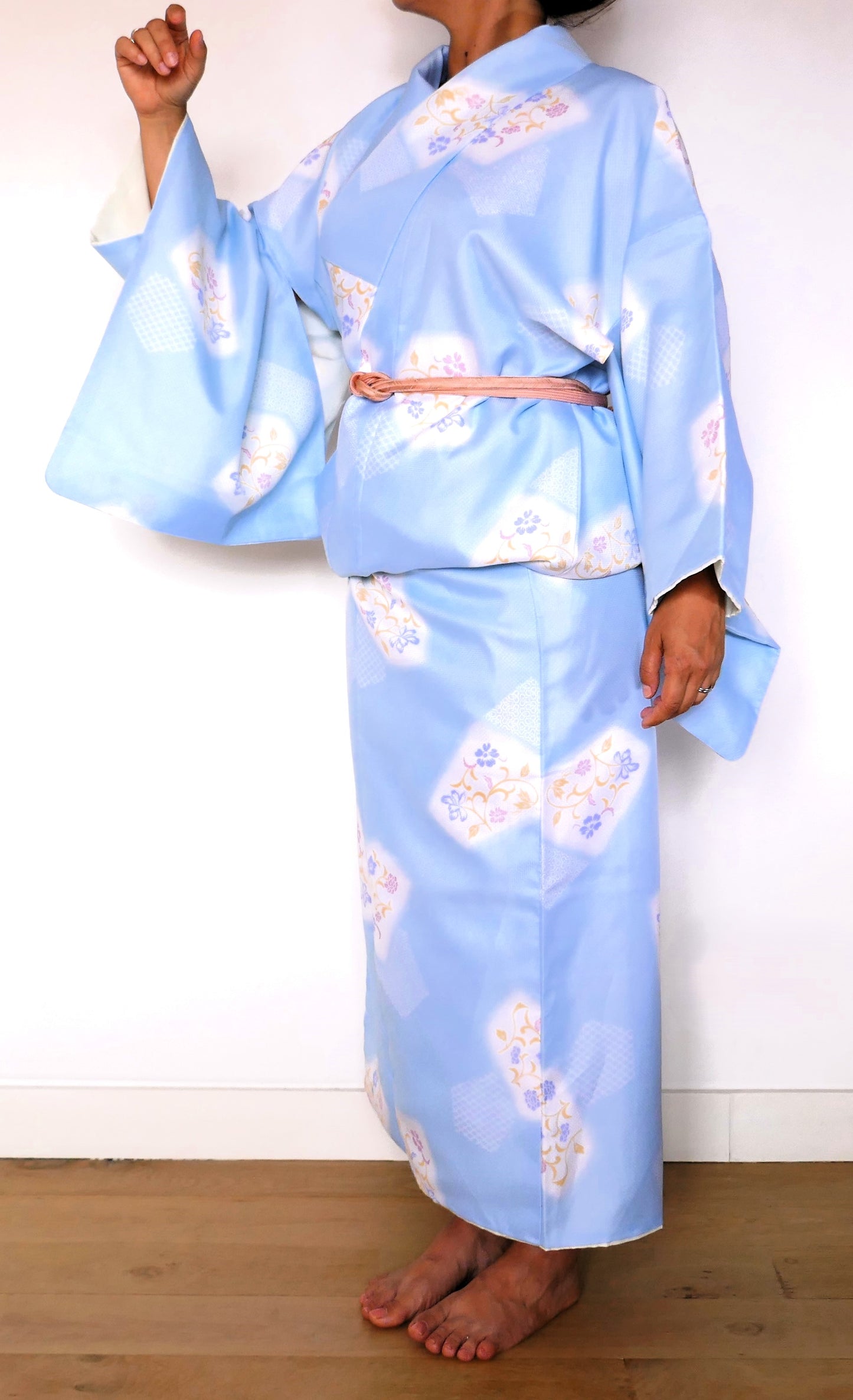 vue de trois quart du yukata bleu ciel fleuri porté avec une manche relevée