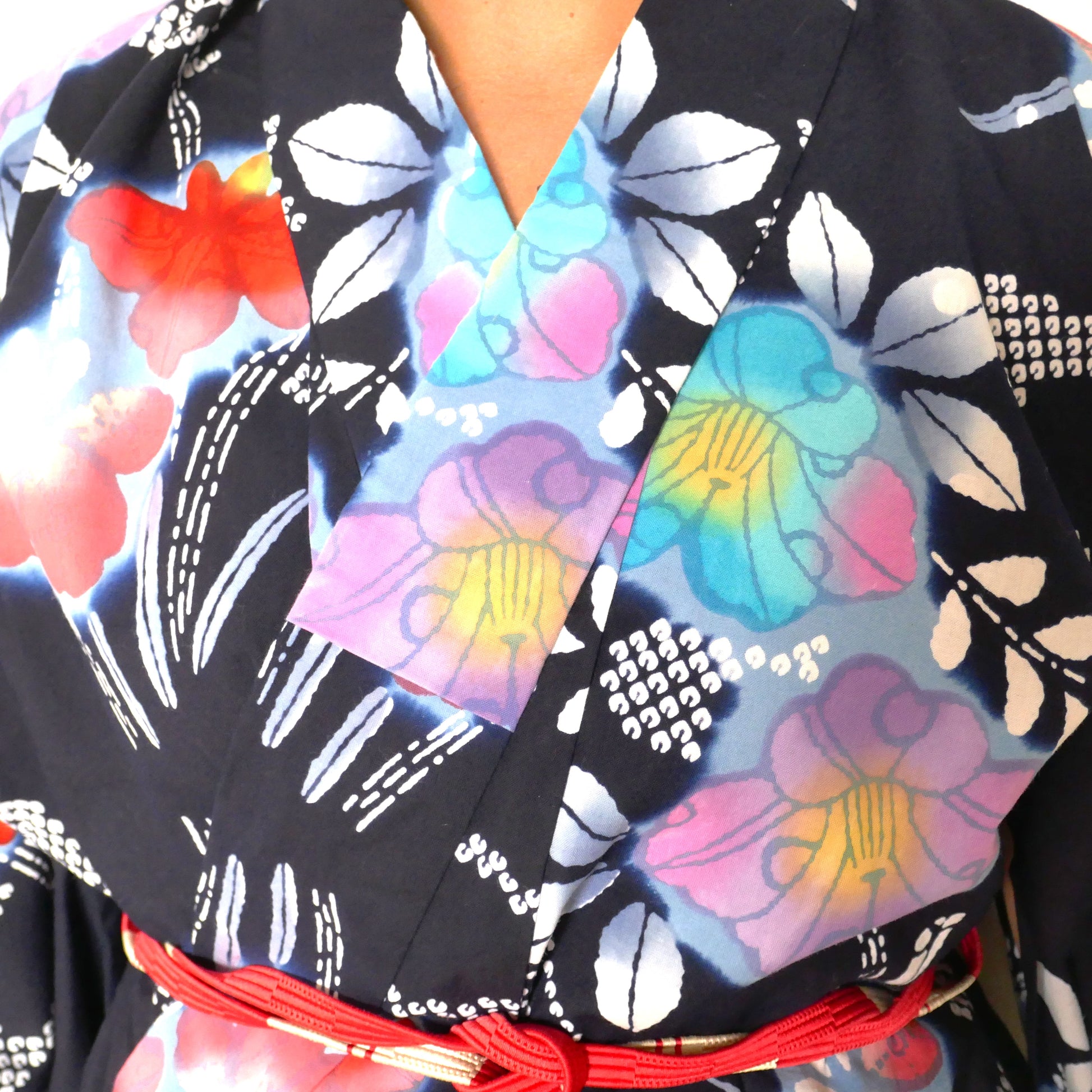 Détail du col d’un yukata en coton bleu marine porté, avec obijime rouge.