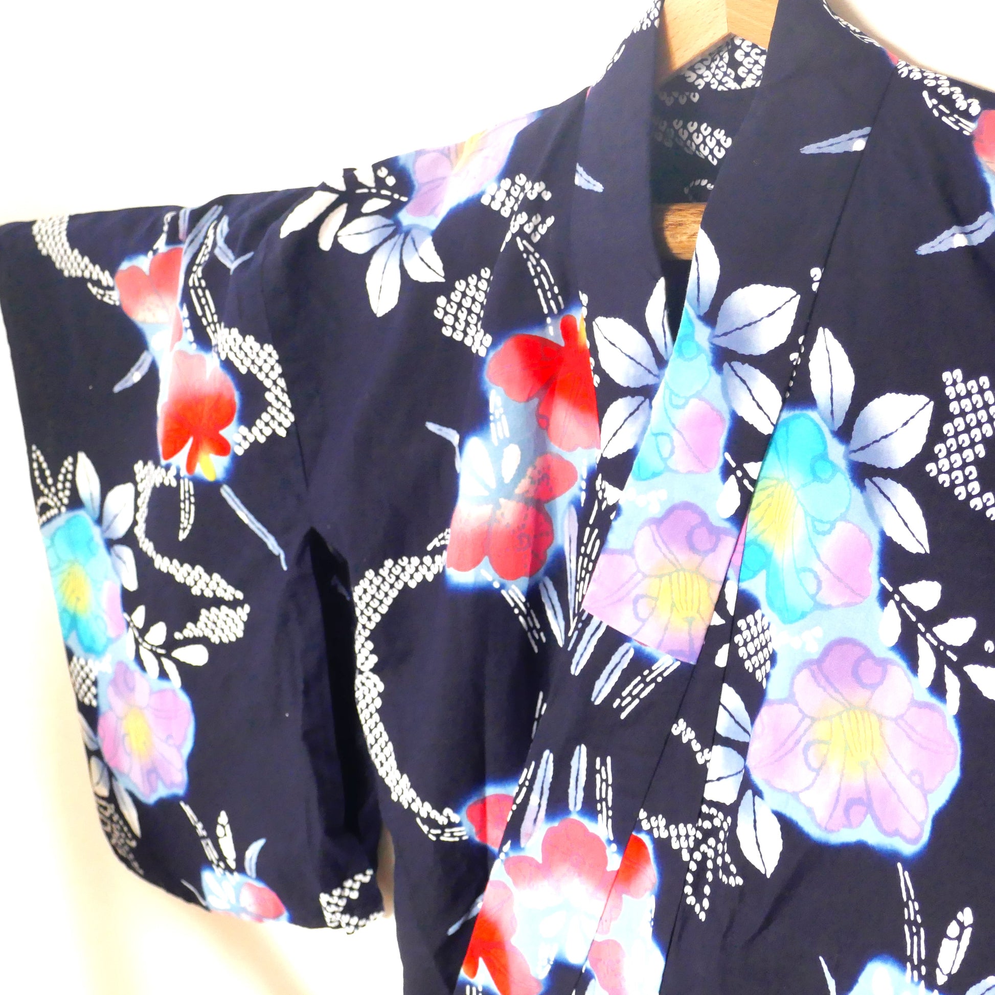 Vue de l’épaule et de la manche d’un yukata bleu marine fleuri.