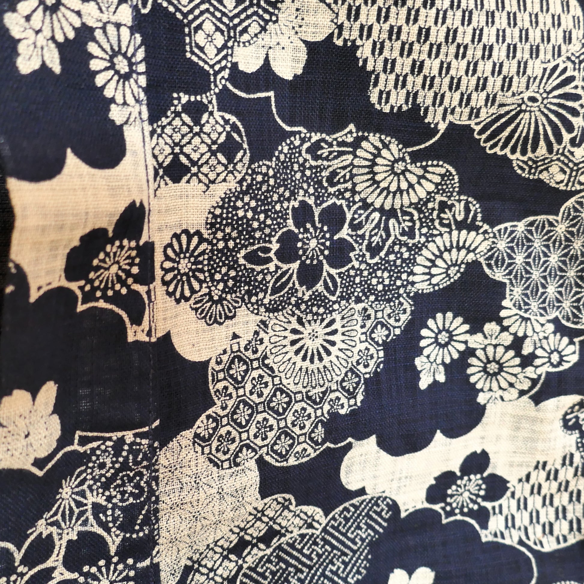 zoom sur les motifs beiges sur fond indigo du haori japonais kumo no hana