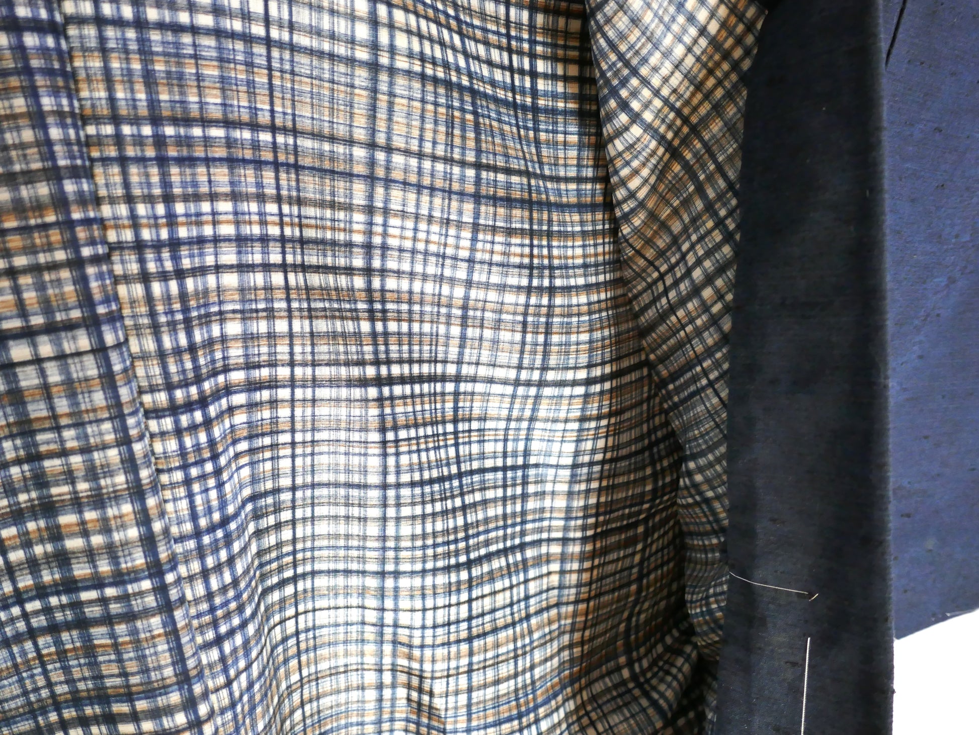 Gros plan sur la doublure intérieure en soie à motif quadrillé d’un haori