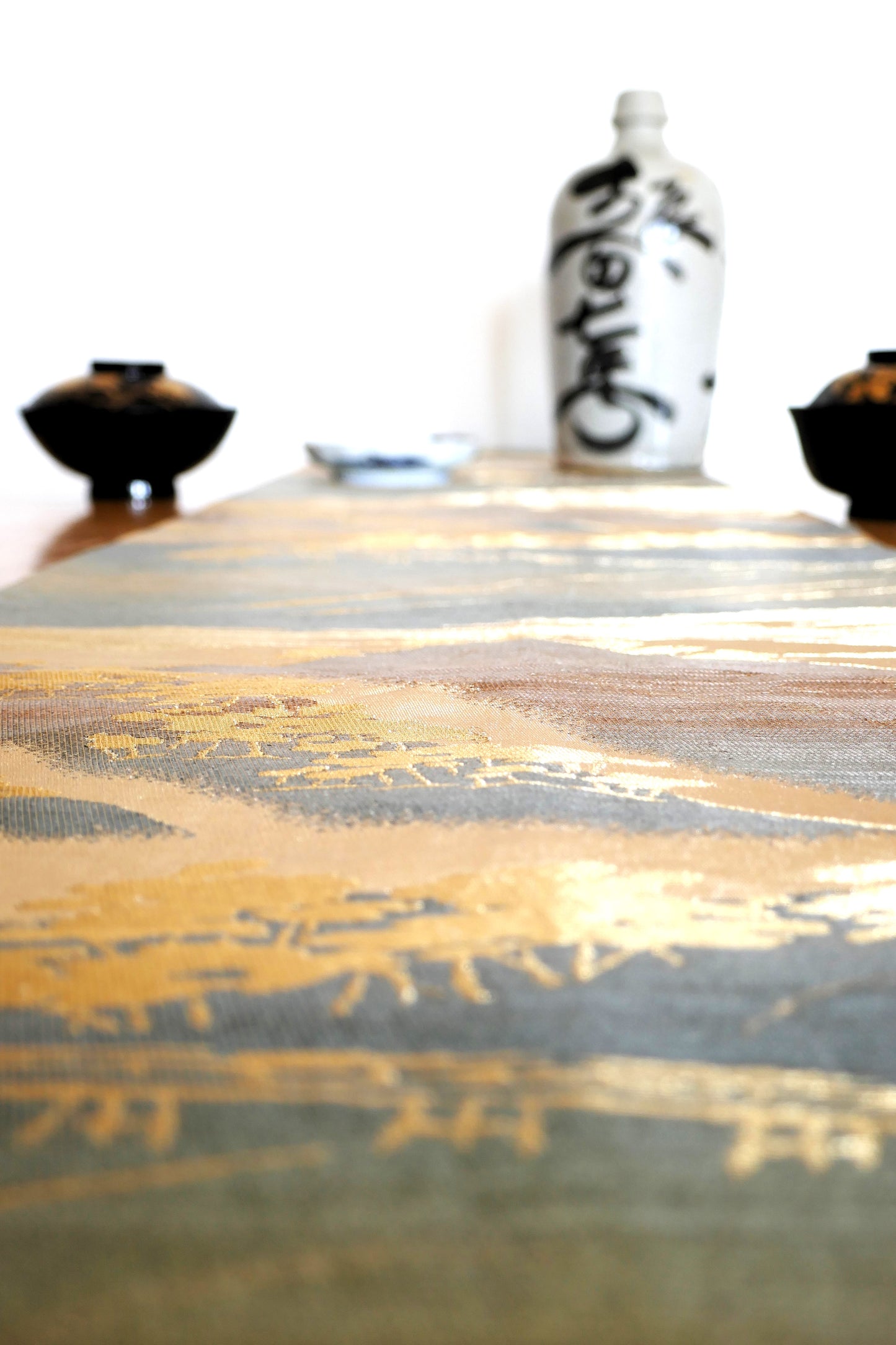 zoom sur les reflets dorés et métalisés du fukuro obi fuji posé sur table
