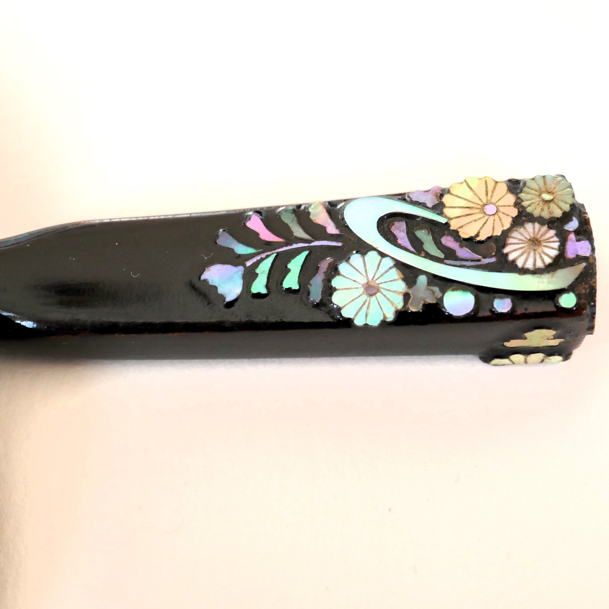 zoom sur l'épingle kogai kogedo noir laquée avec motifs fleuris en nacre reflets bleu et rose