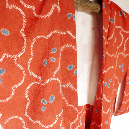 Haori vintage japonais en soie orange à motifs floraux blancs et bleus, époque Shōwa – détail de la doublure visible.
