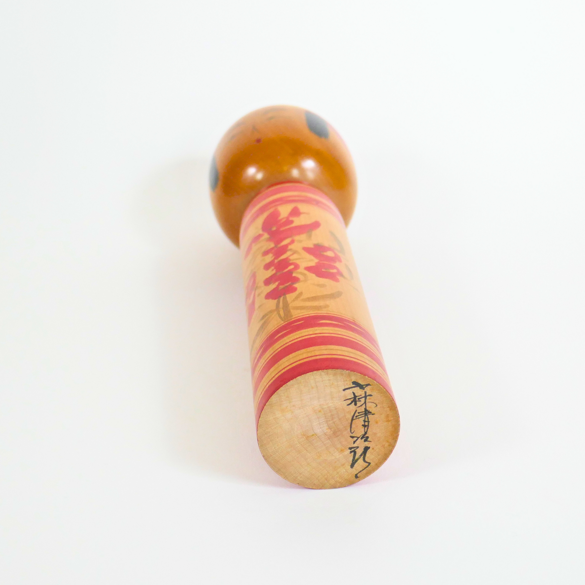 signature de l'artiste kobayashi seijiro sur une kokeshi en bois