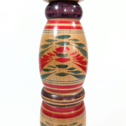 Détail du corps d’une Kokeshi Yajiro de Sato Naoki, présentant un motif floral stylisé peint à la main, typique de l’époque Showa.