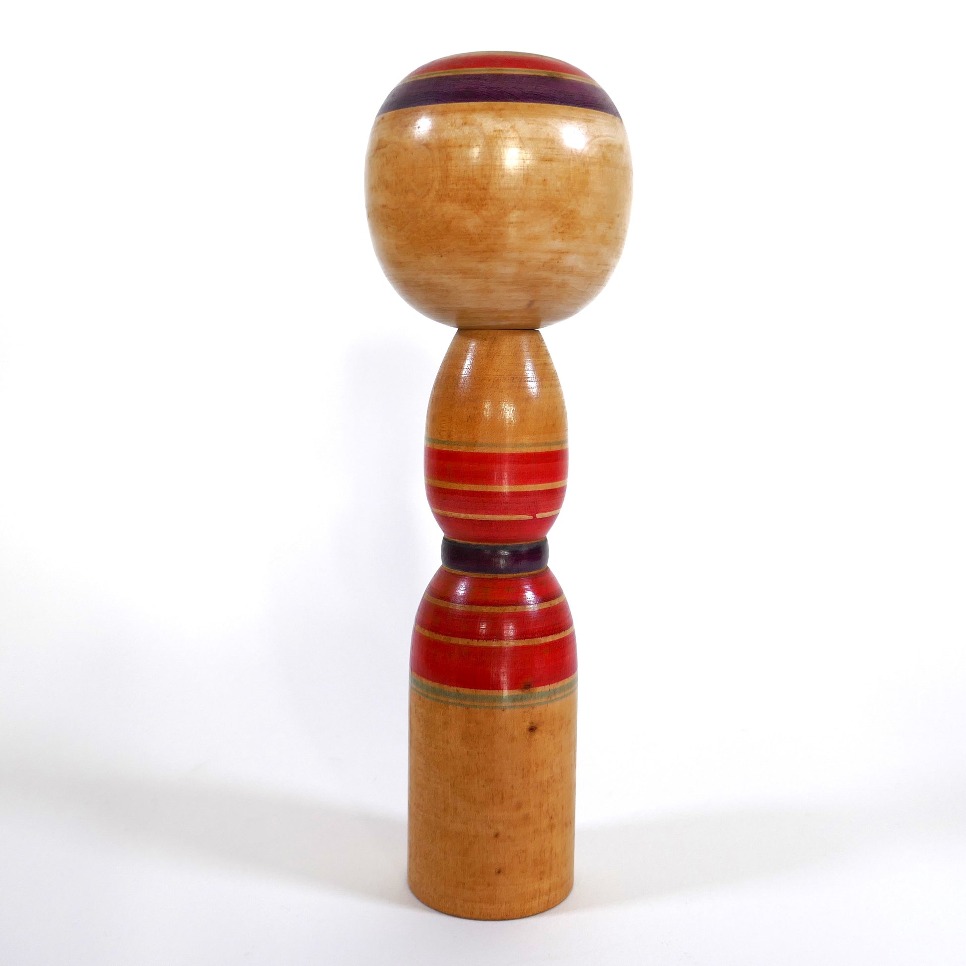 Vue arrière d’une kokeshi traditionnelle Yajirō de Niiyama Fukuo, anneaux décoratifs rouges
