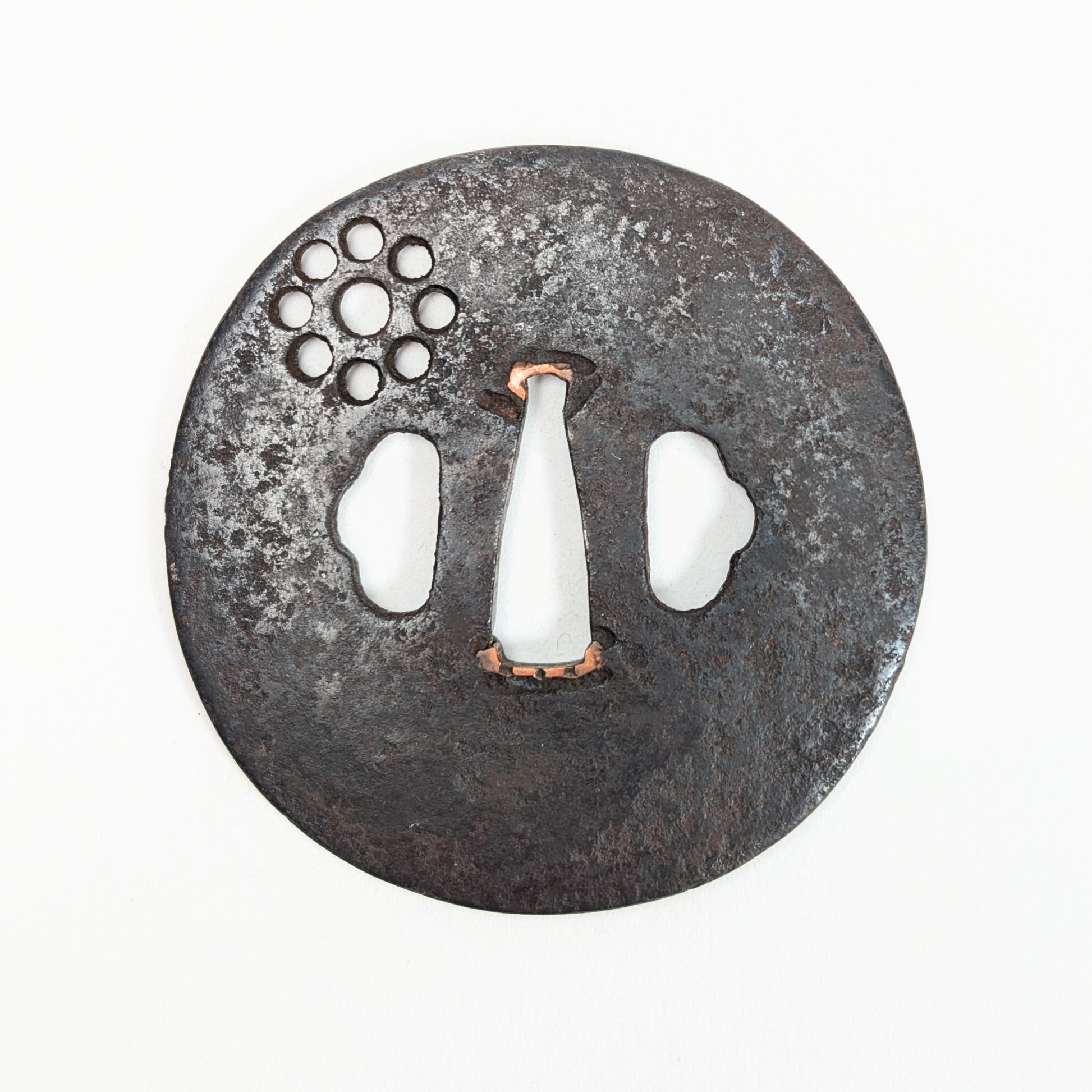 Antiquité japonaise en fer : ancienne tsuba de sabre à décor Kuyō sukashi, hitsu-ana et sekigane en cuivre.