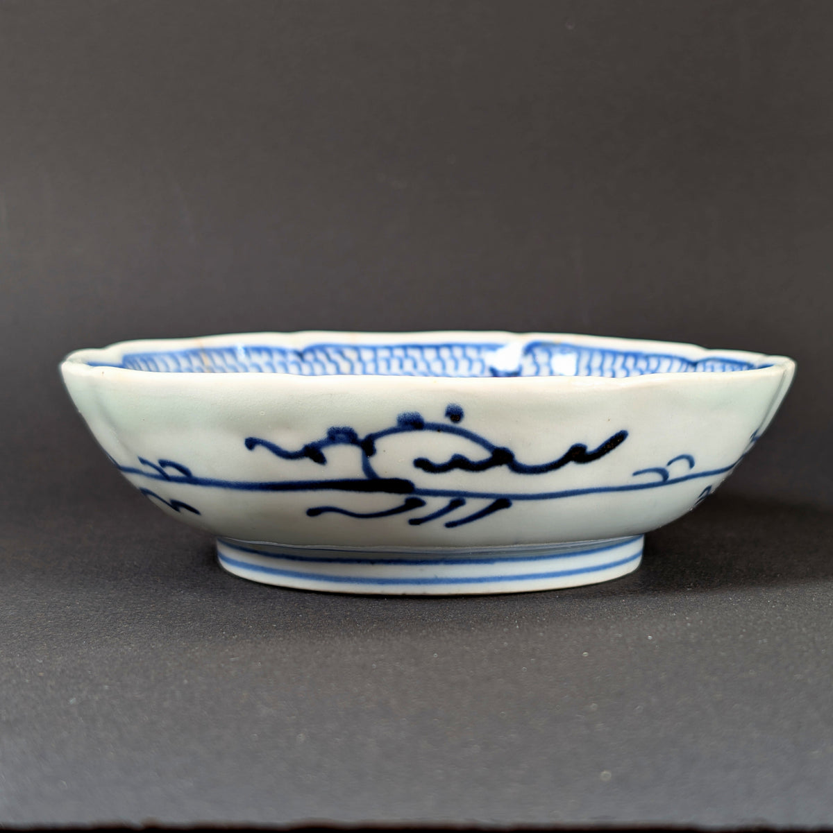 Profil d’une assiette creuse japonaise Imari à bord rinka polylobé, porcelaine ancienne bleu et blanc