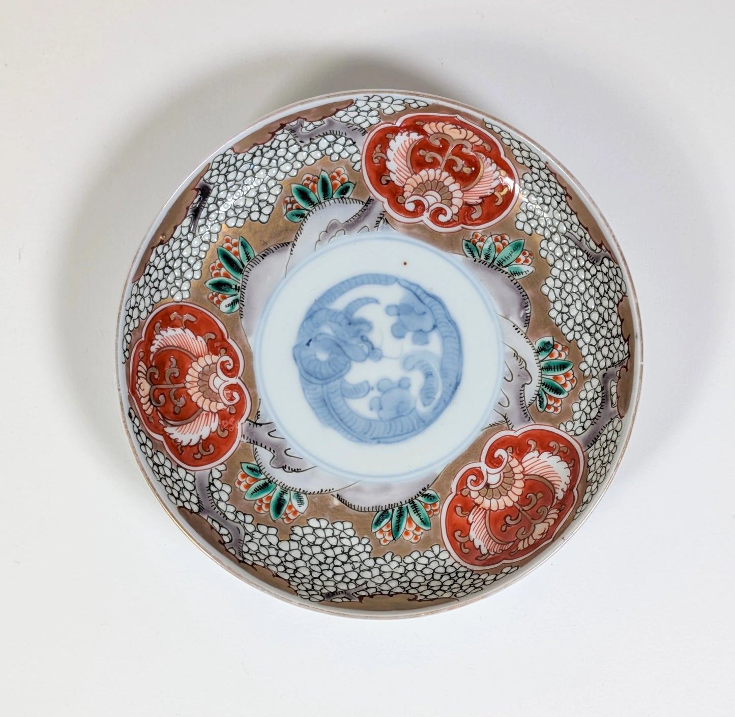 Vue de dessus d’une assiette Imari Arita, porcelaine japonaise ancienne à décor floral polychrome, fin Edo – début Meiji