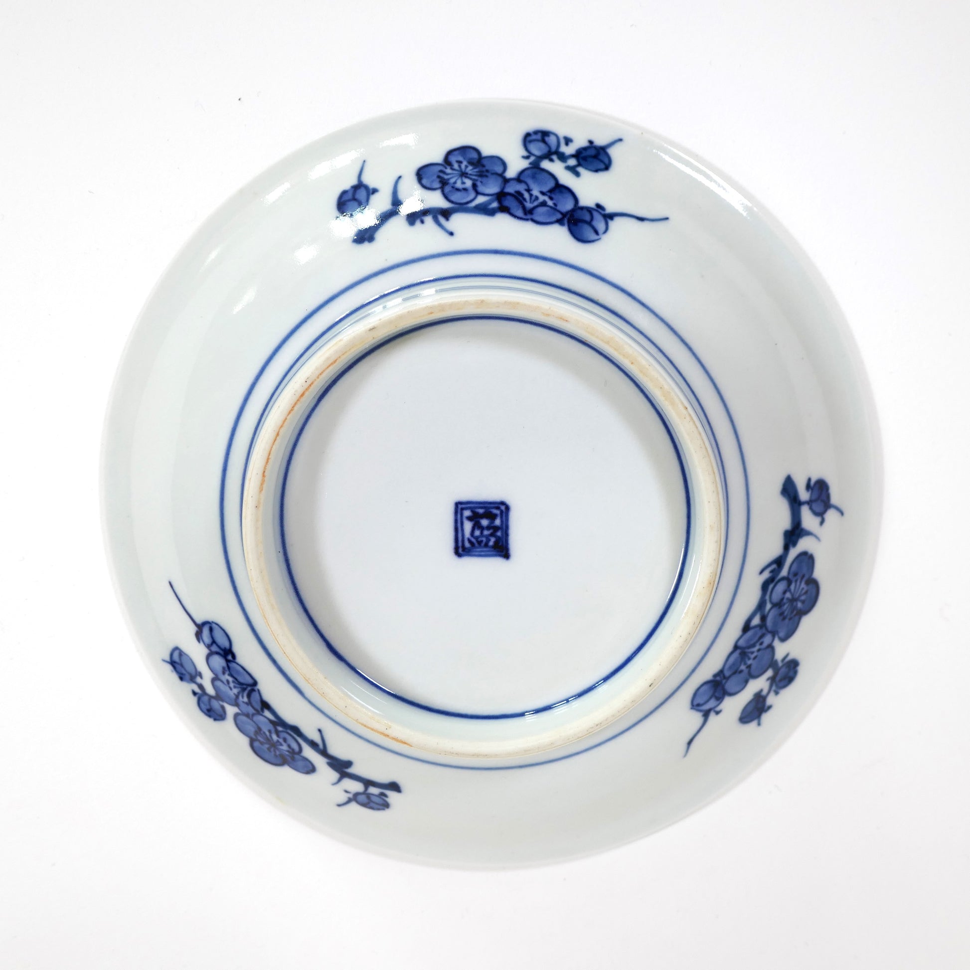 Assiette Imari Arita vue de face, décor polychrome Sho Chiku Bai (pin, bambou, prunier), émaux rouge, jaune, vert et bleu. Kanji 藍 (Ai), marque régionale de Hizen par Iwao Engineering