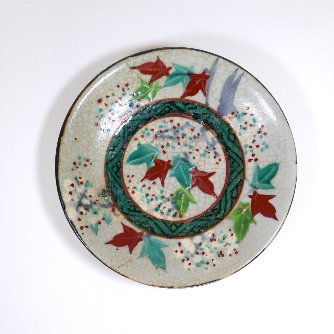 Assiette japonaise Inuyama-yaki de l'époque Edo, décorée de feuilles d'érable rouges et vertes (momiji), vue de profil avec émail craquelé.