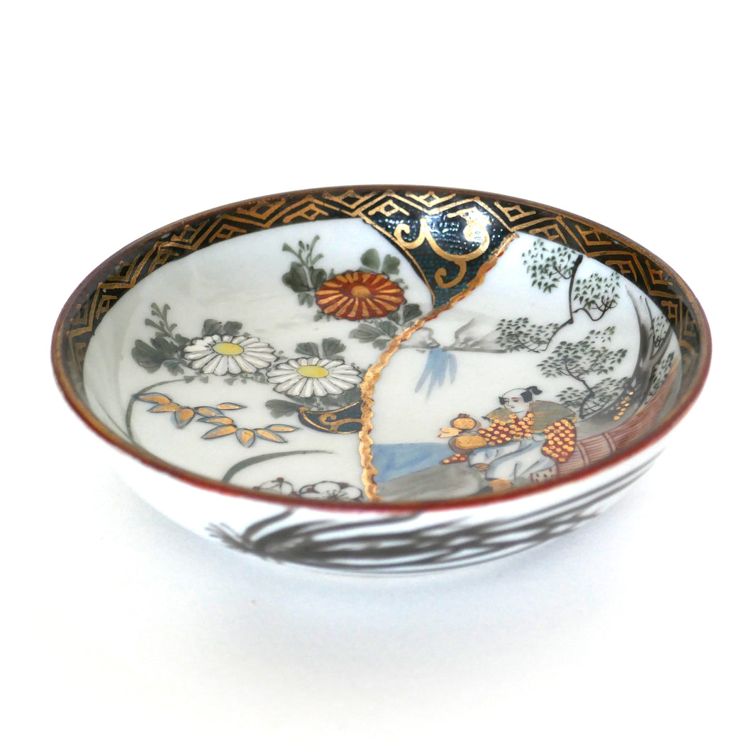 Assiette japonaise Kutani en porcelaine avec personnage traditionnel, fleurs et dorures sur fond blanc