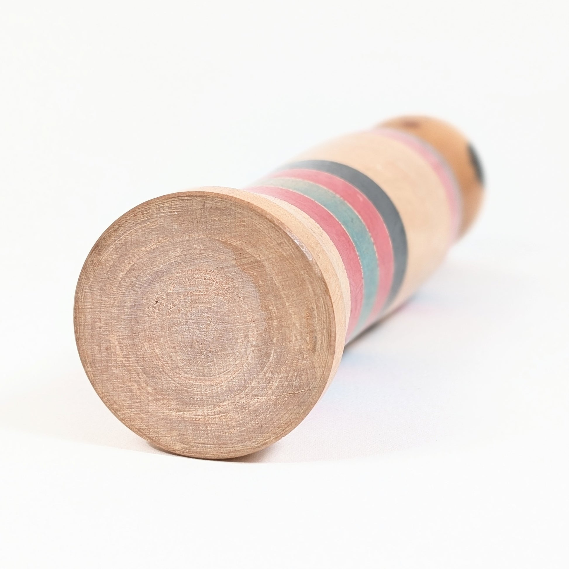 Base en bois tourné d’une kokeshi Kijiyama traditionnelle, montrant le travail du bois et la patine de l’artisanat japonais