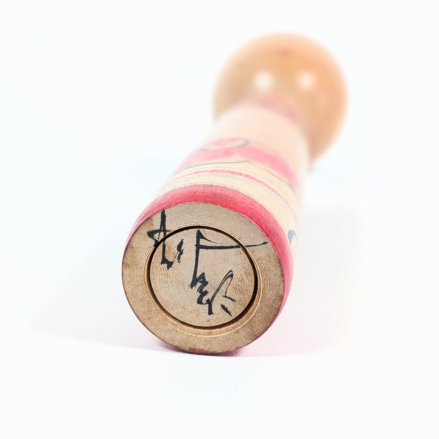 Base signée d’une kokeshi artisanale japonaise attribuée à Arakawa Yōichi.