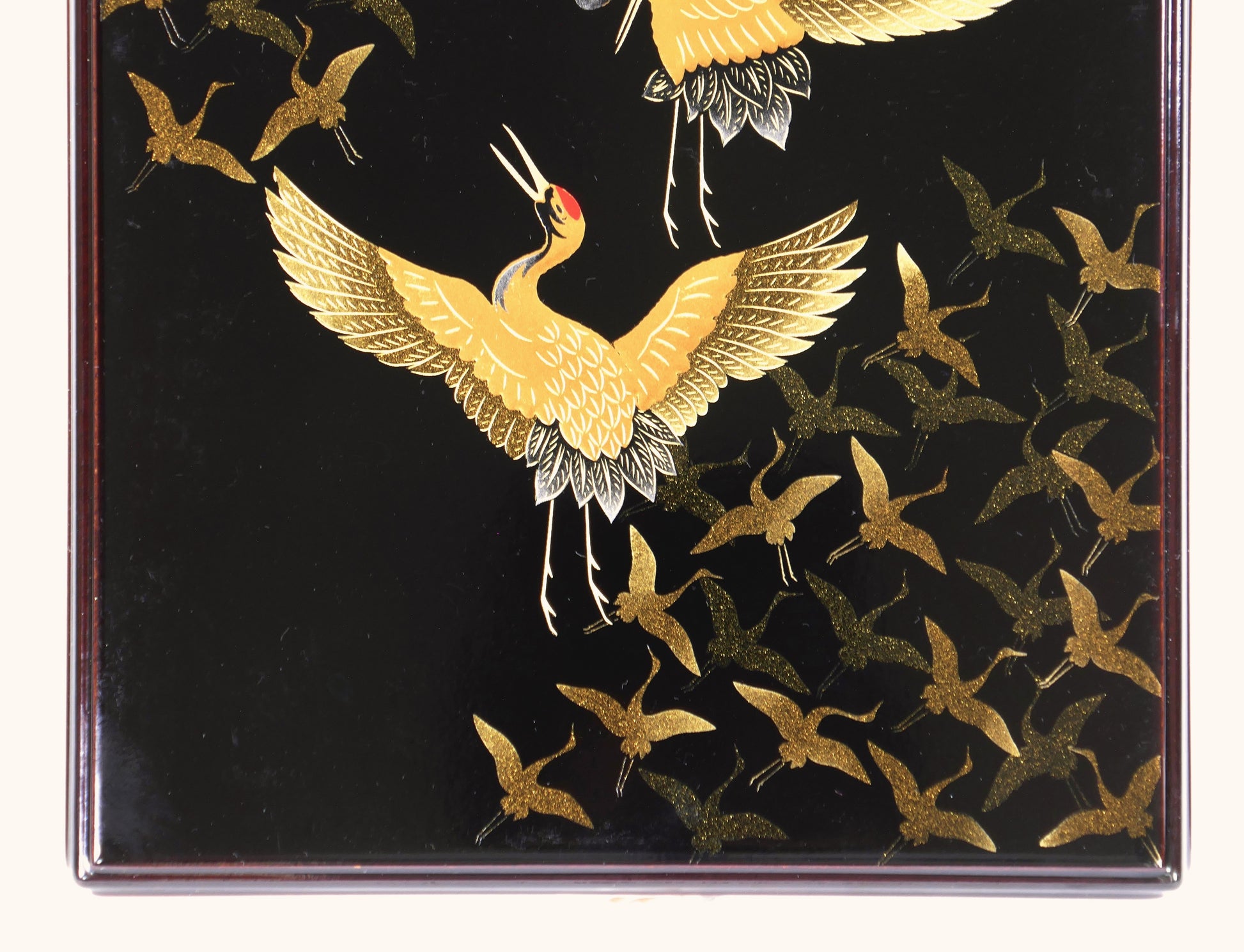Zoom sur une grue dorée décorée en maki-e avec effets de nashiji