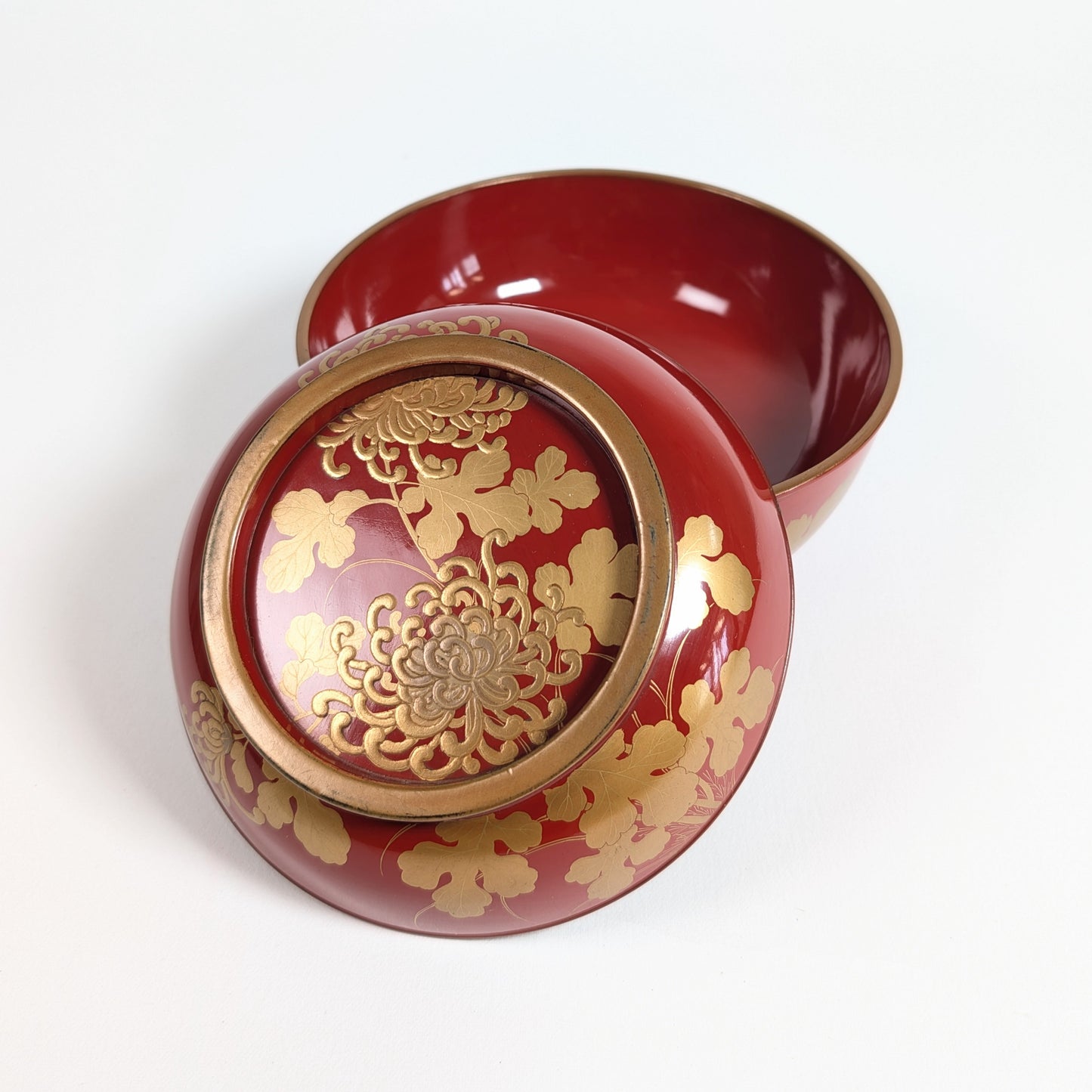 Bol japonais en bois laqué rouge avec son couvercle décoré de maki-e doré, chrysanthèmes et feuillages de kiku.