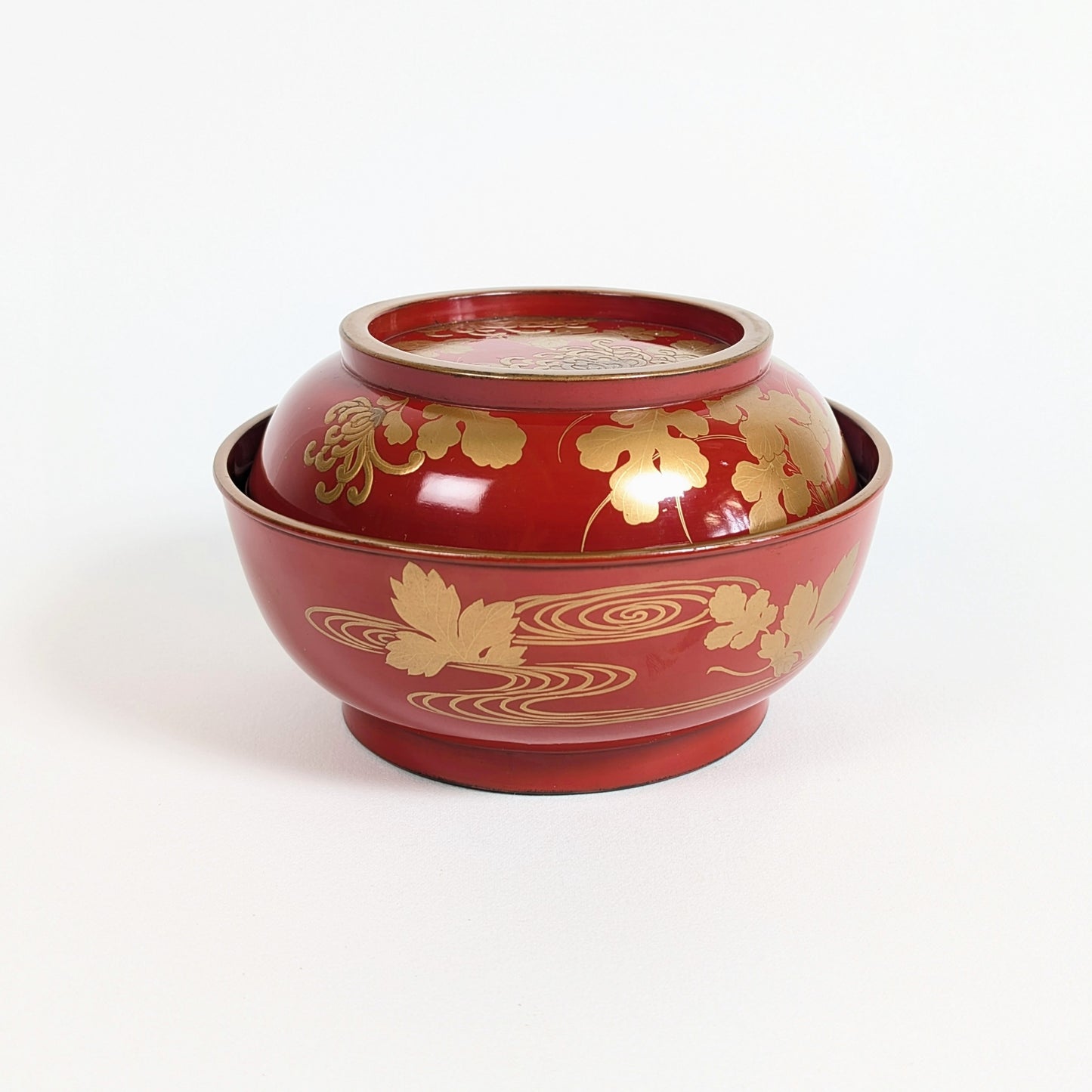 Bol japonais couvert en bois laqué urushi vermillon, décor kikusui de chrysanthèmes et eaux courantes en maki-e doré.