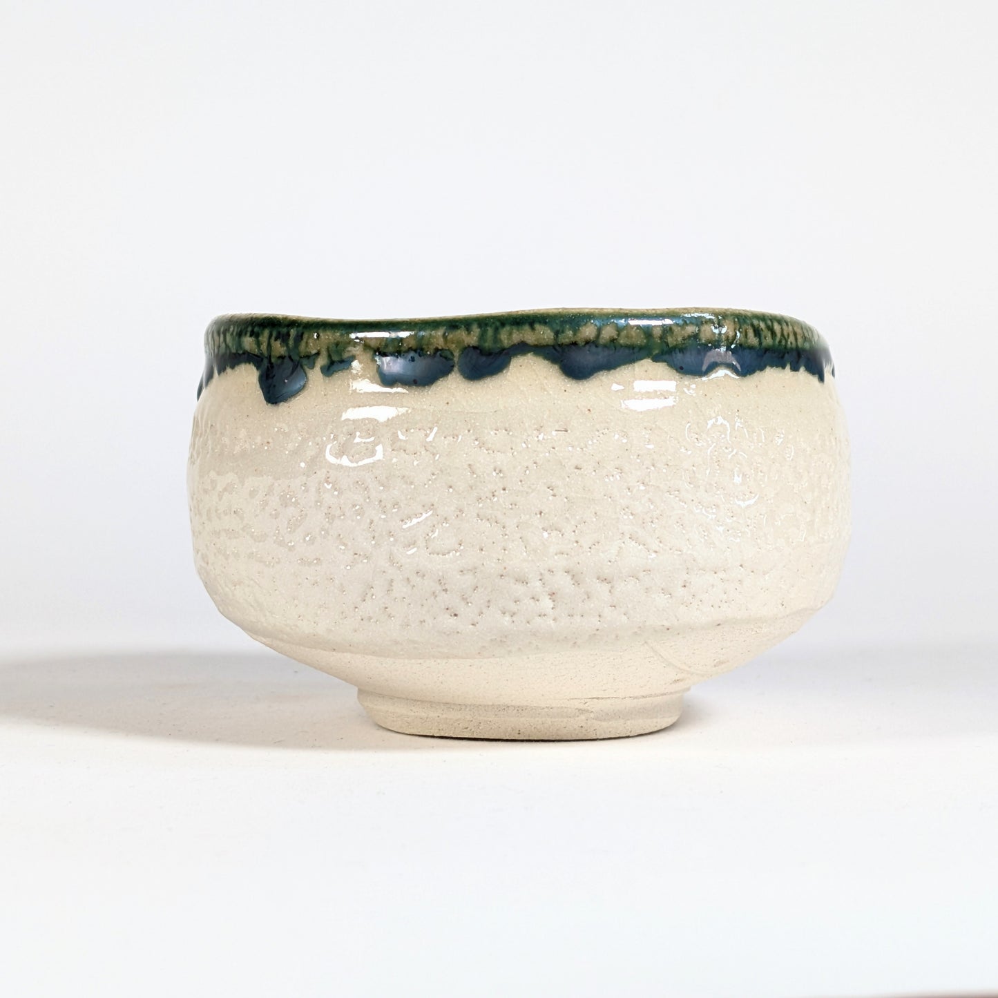 Bol matcha japonais Oribe en céramique Mino-yaki, profil montrant le bord vert profond et la texture craquelée