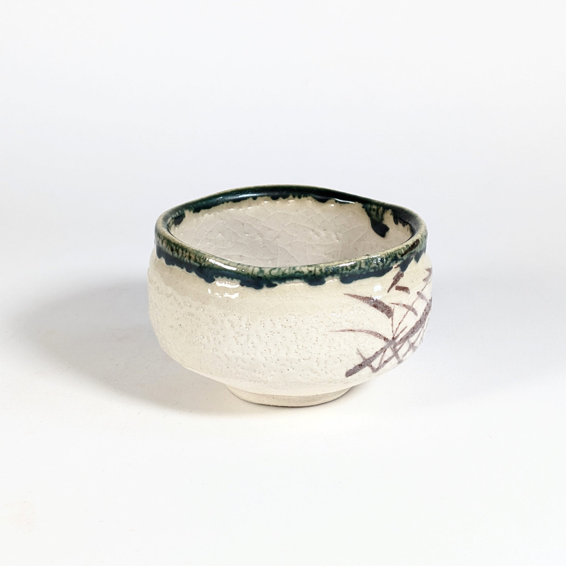 Bol matcha Oribe-yaki artisanal avec bord vert profond, émail crème craquelé et décor brun partiel