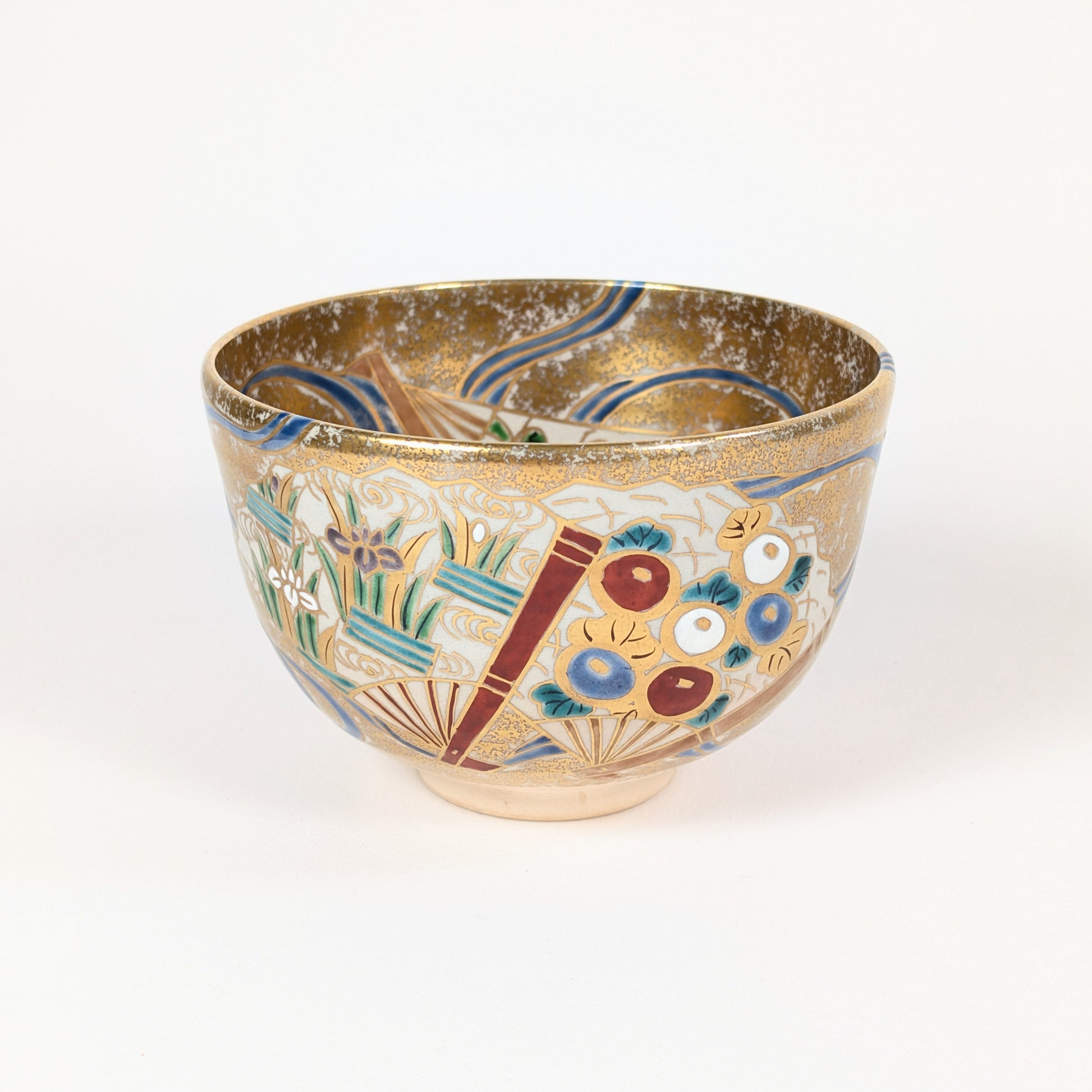Bol à thé japonais orné d’éventails, d’iris stylisés, de fleurs polychromes et d’un décor kinrande à l’or.