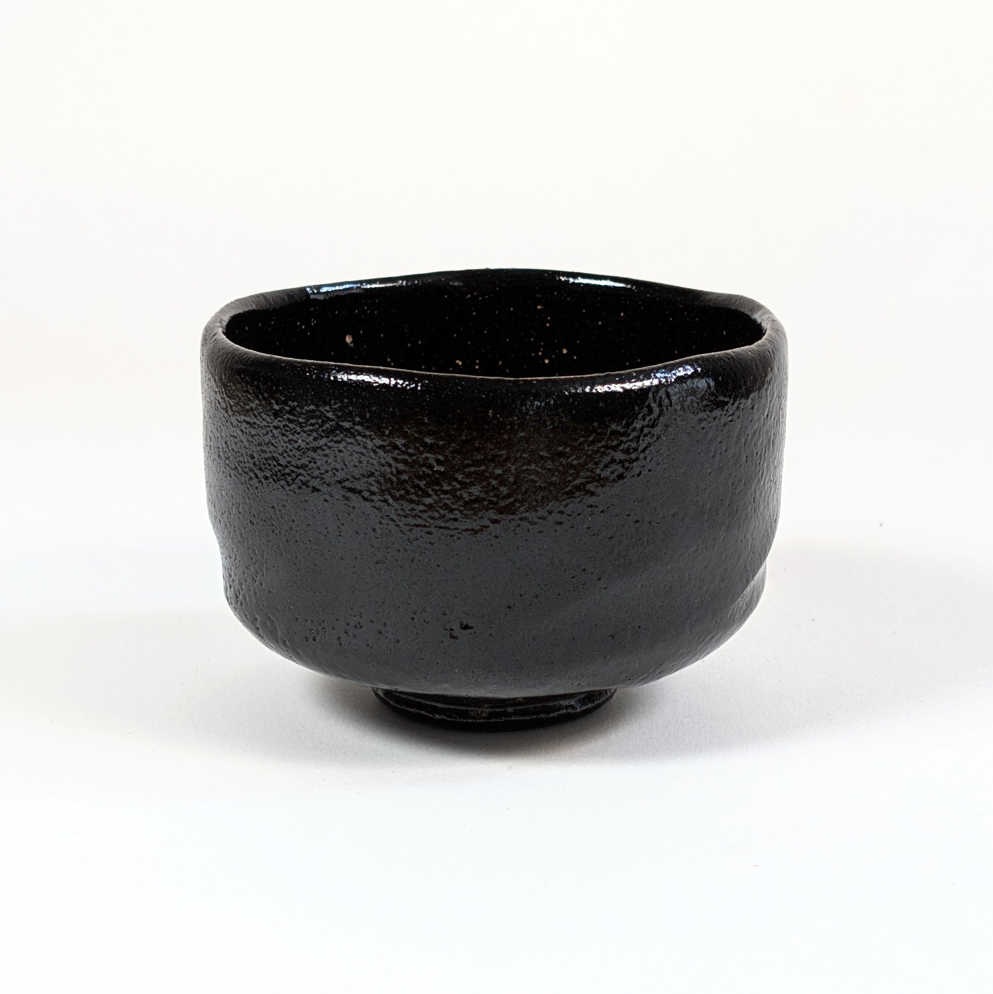 Bol à thé matcha noir au bord irrégulier, conçu pour le sadō et l’art traditionnel japonais de la cérémonie du thé.
