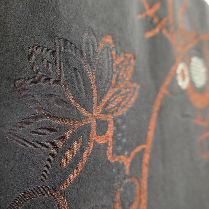 Détail du brocart de soie d'une veste haori japonaise, orné de feuilles stylisées et d'arabesques végétales cuivrées d'inspiration karakusa.