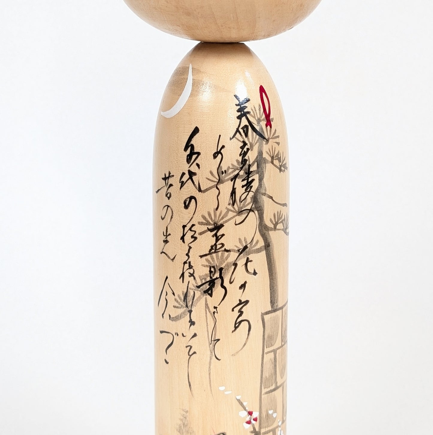 Détail de la calligraphie japonaise du modèle Kōjō no Tsuki 荒城の月 sur une kokeshi signée Shūhō.