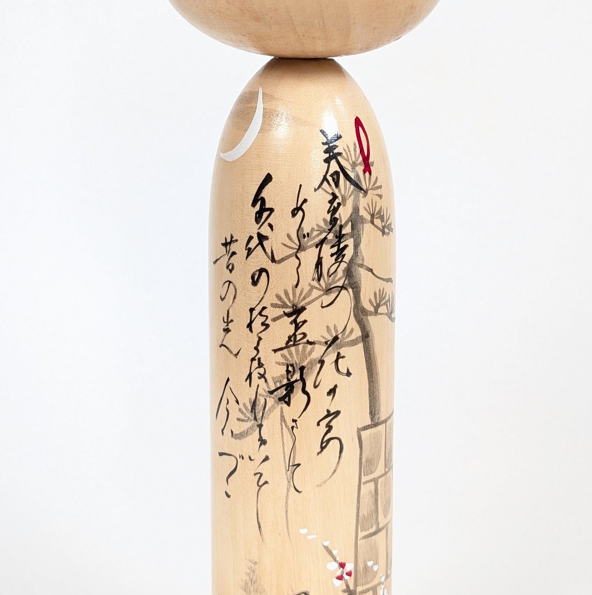 Détail de la calligraphie japonaise du modèle Kōjō no Tsuki 荒城の月 sur une kokeshi signée Shūhō.