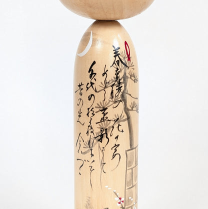 Détail de la calligraphie japonaise du modèle Kōjō no Tsuki 荒城の月 sur une kokeshi signée Shūhō.