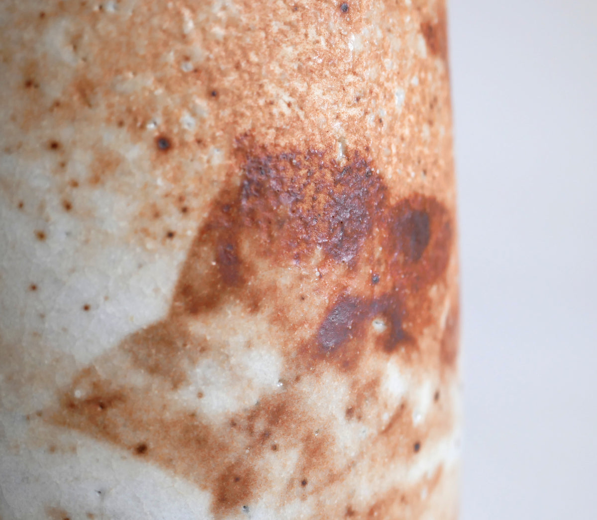 Détail des taches brun rouille et des variations ferrugineuses sur une céramique japonaise Shino de Hironaga-gama.