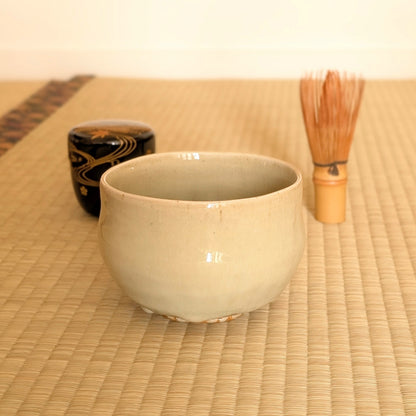Chawan Akahada-yaki par Onishi Rakusai présenté sur tatami avec chasen et natsume pour la cérémonie du thé japonaise