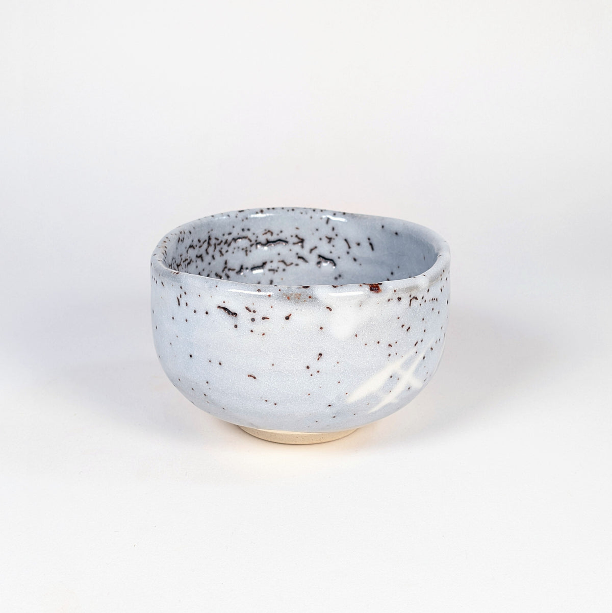 Chawan artisanal japonais de Tajimi en vue oblique, céramique Shino de Mino à glaçure gris bleu mouchetée.
