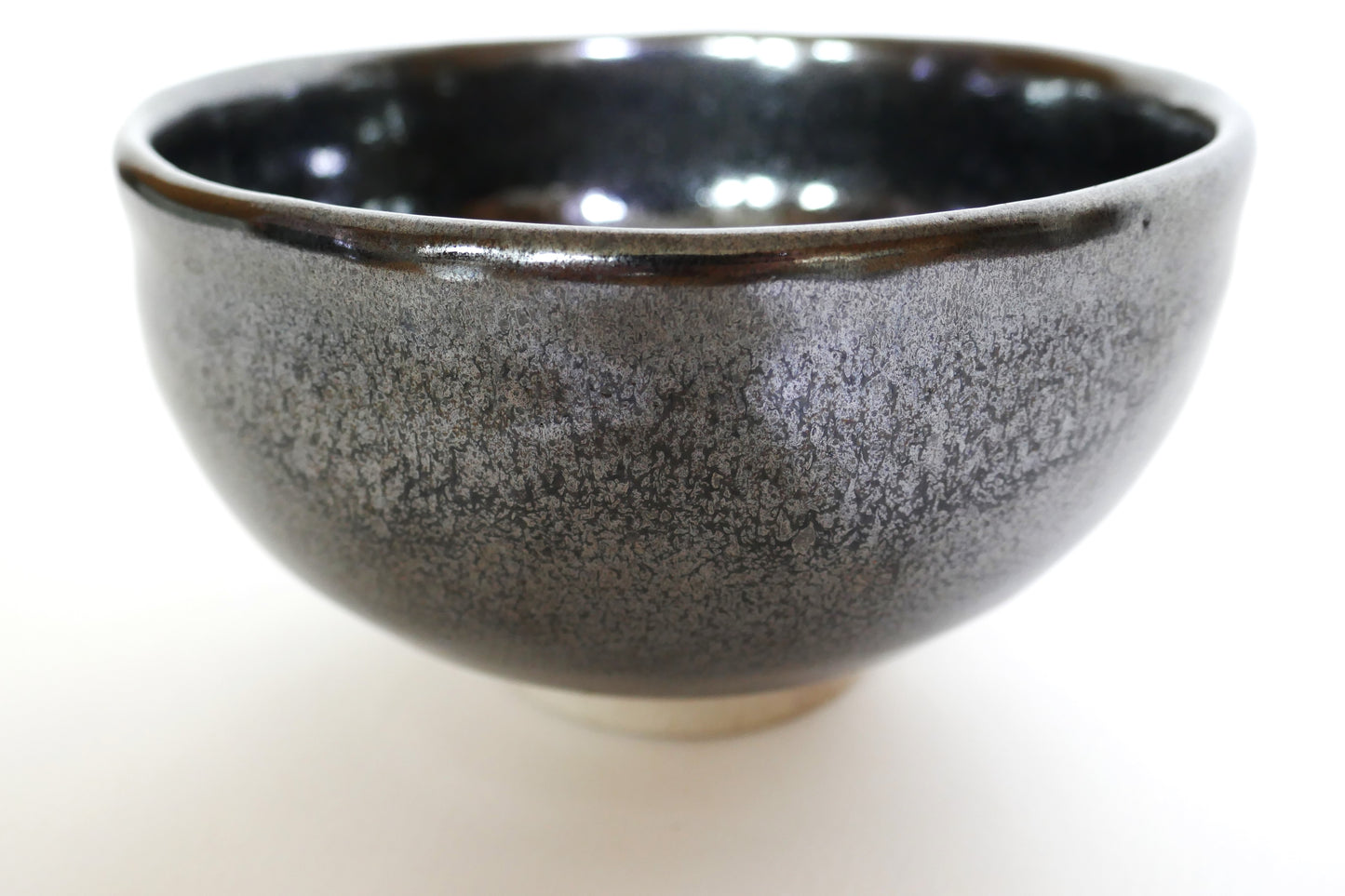Gros plan sur la glaçure noir avec cendre haïyu du chawan Komogai-nari, bol à thé japonais de Taniguchi Akikazu, Seto-yaki