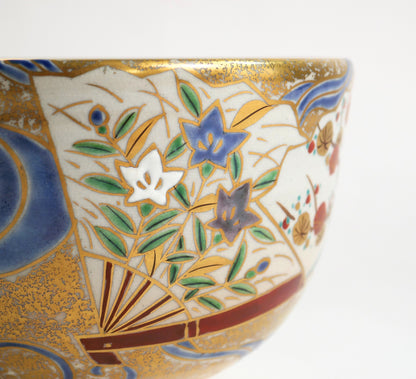 Gros plan du décor iro-e et kinrande du chawan de style Ninsei, avec campanules japonaises kikyō peintes sur un éventail.
