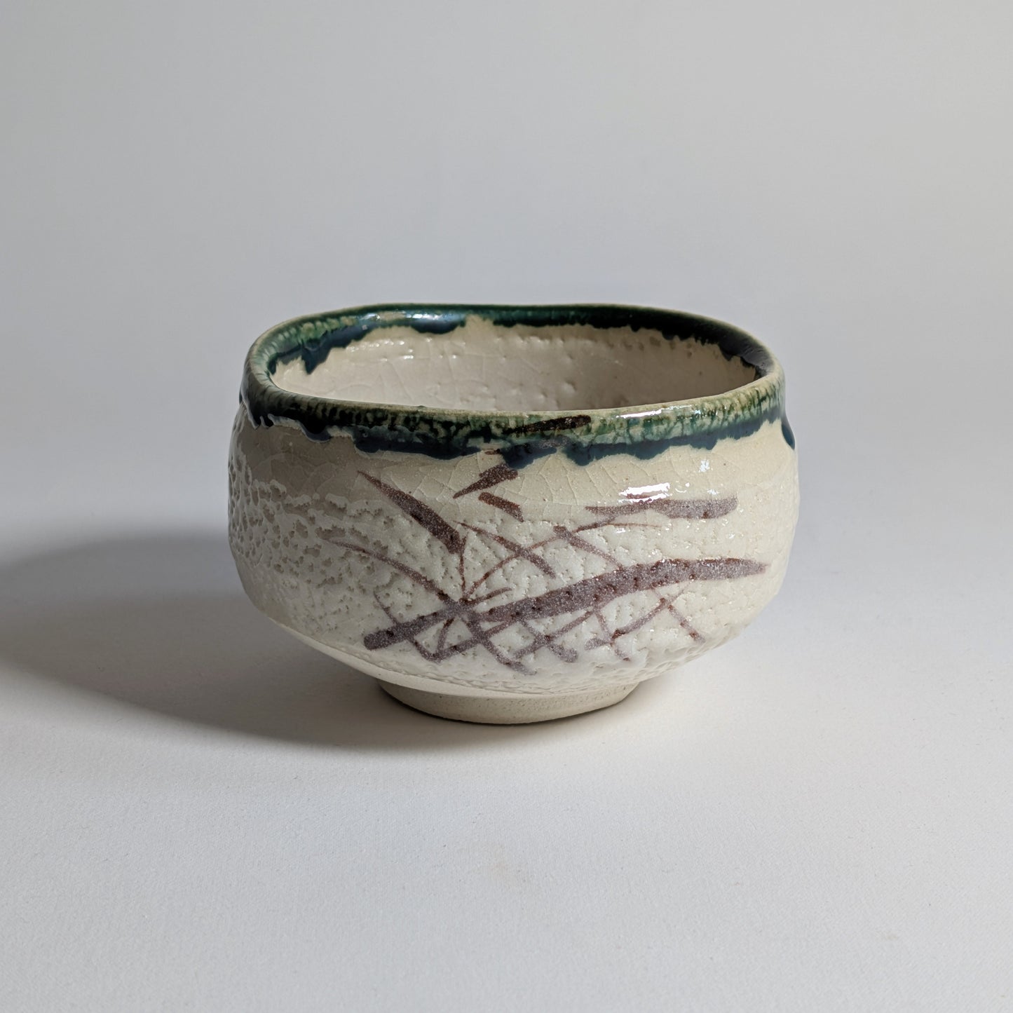 Chawan Oribe-yaki, bol matcha japonais en céramique crème avec décor brun abstrait et bord à glaçure verte