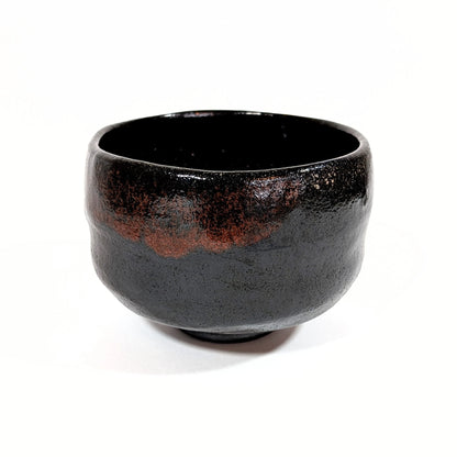 Bol à thé kuro raku aux reflets rougeâtres, réalisé par Sasaki Shoraku, artisan potier de Kyoto.