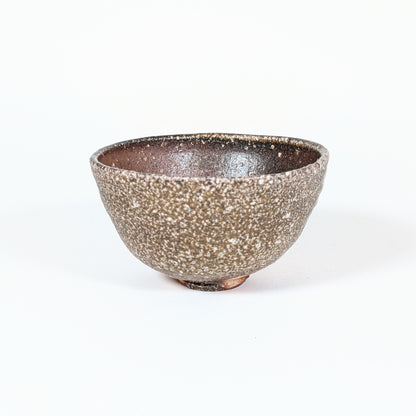 Face fortement cendrée du chawan Shigaraki de Naohiko Koyama, avec texture minérale, ishihaze et effets de cuisson