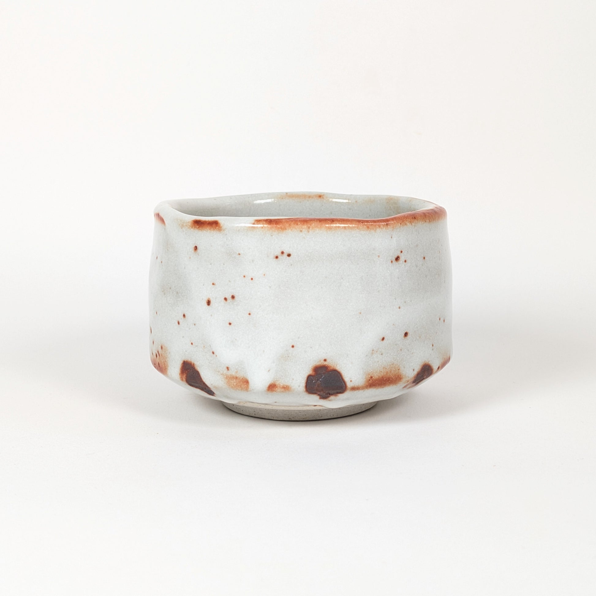 Chawan Shino-yaki à glaçure blanche laiteuse et traces brun rouille, bol à matcha japonais en céramique de style Mino-yaki.