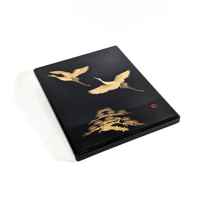 Coffret japonais laqué noir, maki-e de grues dorées et motif végétal, vue trois-quarts.