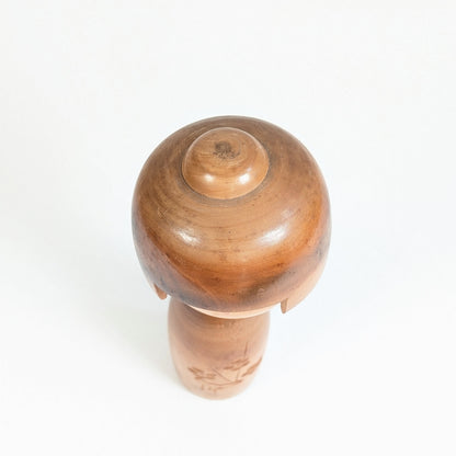 Vue de dessus de la coiffure en bois sculpté de cette kokeshi japonaise de Fujikawa Shōei