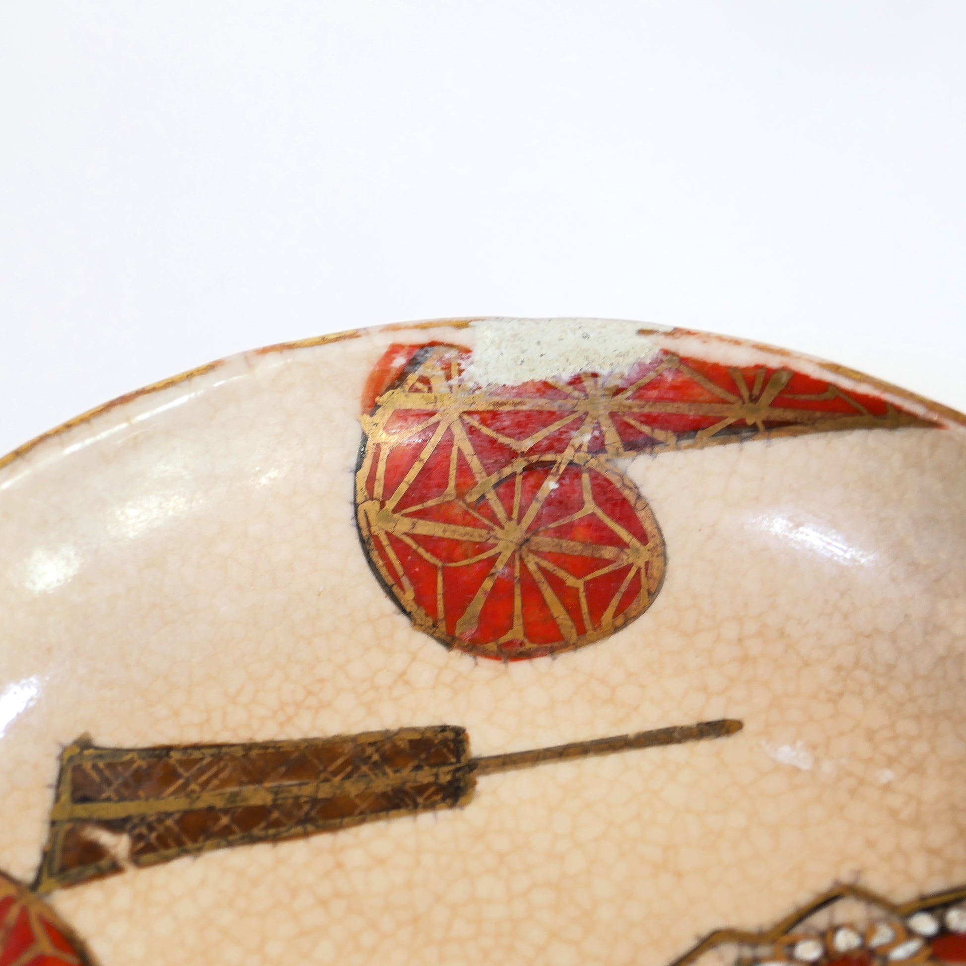 Gros plan sur le bord d’une coupelle Kutani montrant une retouche d’origine typique des céramiques artisanales anciennes