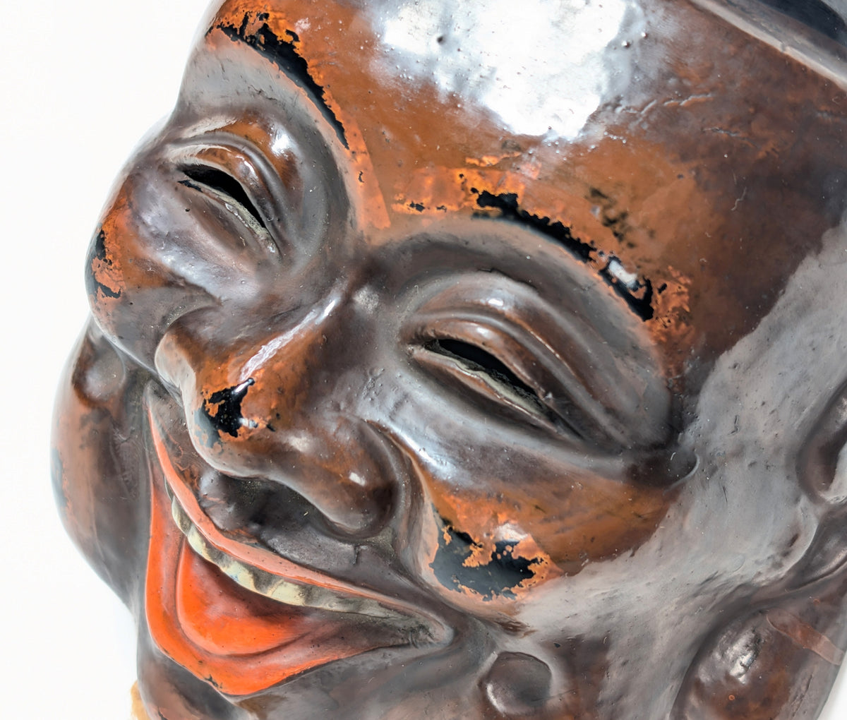 Détail des yeux et du nez d’un masque Daikoku-men en kanshitsu, avec effets de polissage révélant la laque noire sous-jacente.