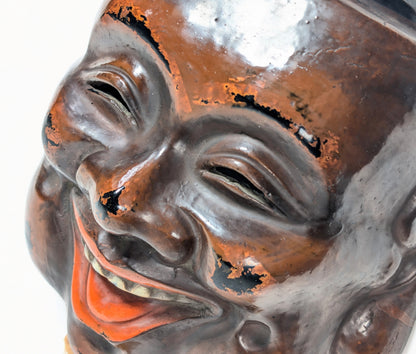 Détail des yeux et du nez d’un masque Daikoku-men en kanshitsu, avec effets de polissage révélant la laque noire sous-jacente.