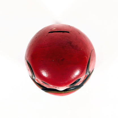 Vue du dessus d’un daruma japonais ancien en céramique rouge